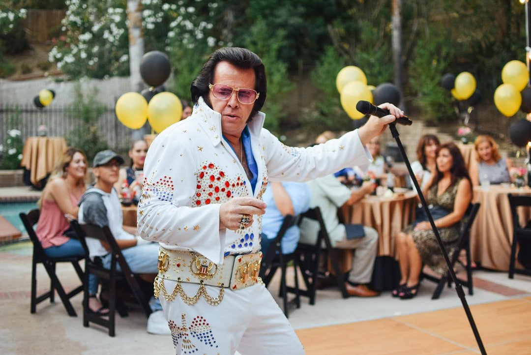 Elvis tribute performer on stage holding a microphone